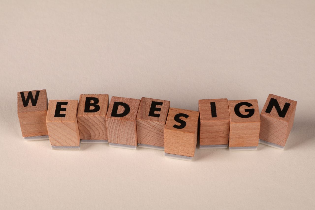 Wooden letter blocks arranged to spell web design creatively present a digital design concept.